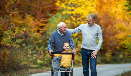 An older man with his family walking in an autumn scene